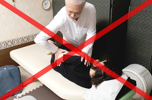 身体をひねるような施術に赤いバツ印が描かれた注意喚起の写真